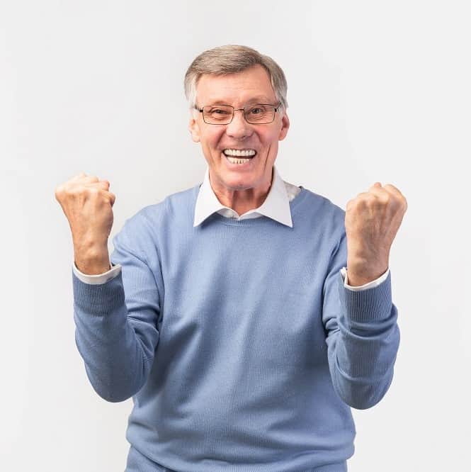Excited Senior Man Shaking Fists Standing Over White Background